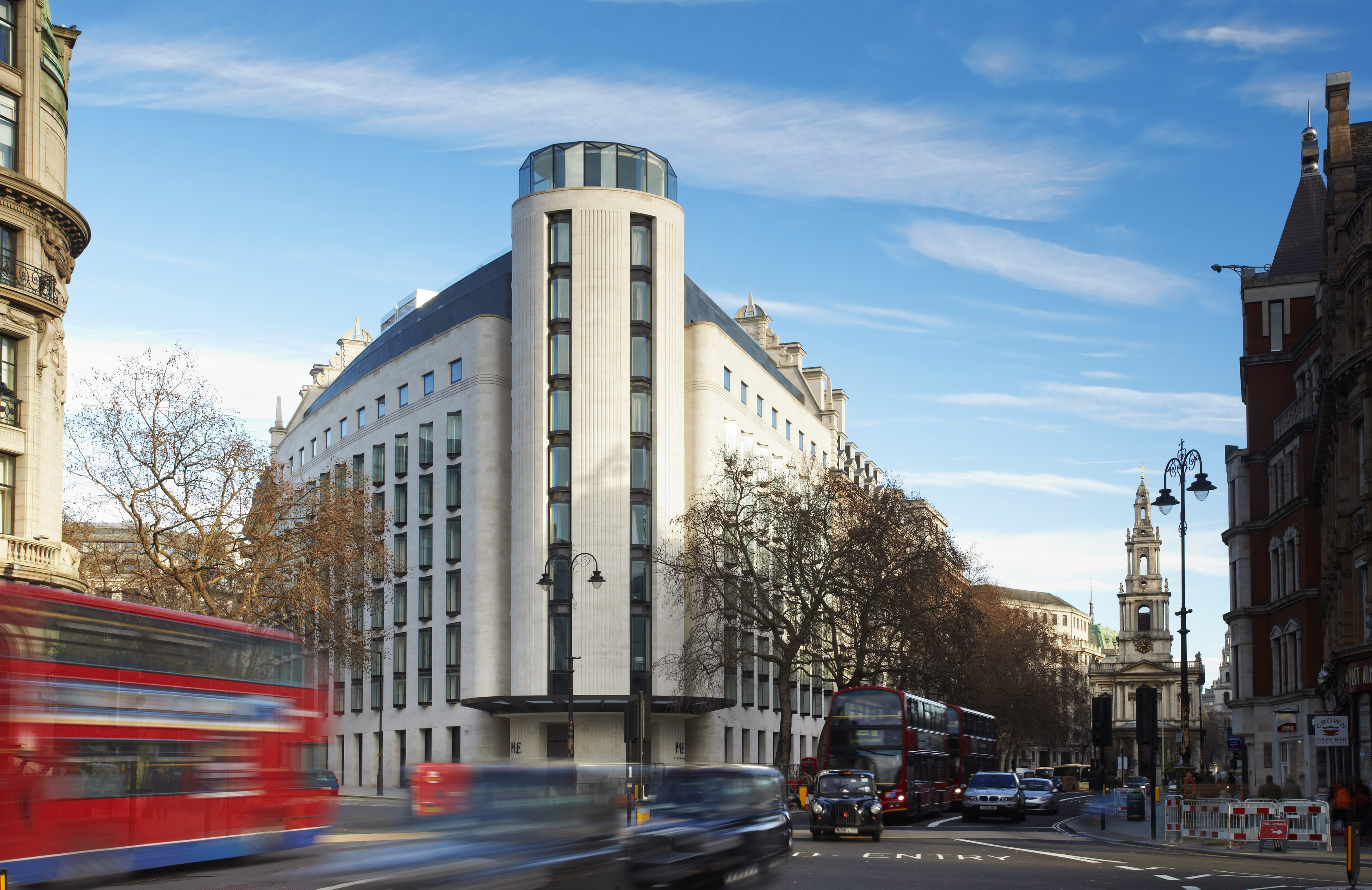 Modern ME London hotel on a busy street with red double-decker buses and black cabs.
