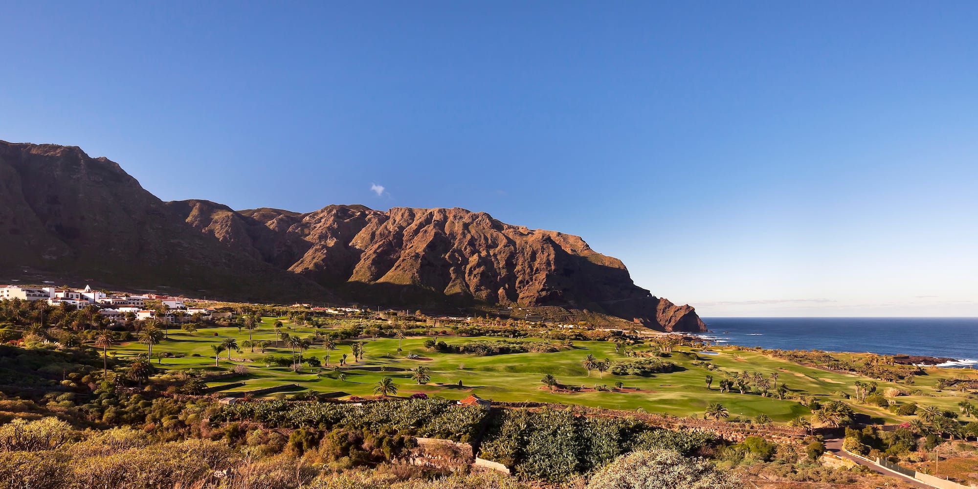a golf course with a mountain in the background