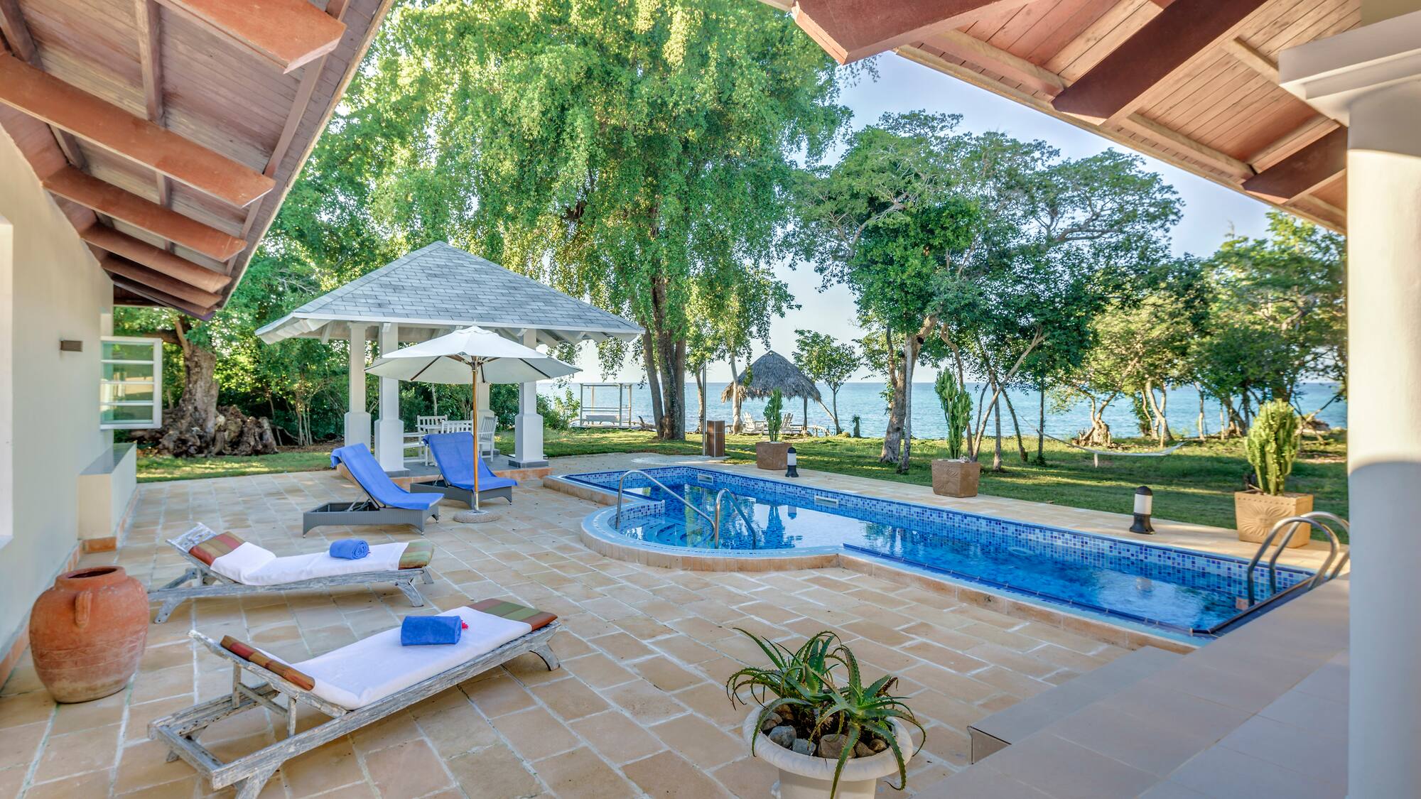 a pool with lounge chairs and a gazebo