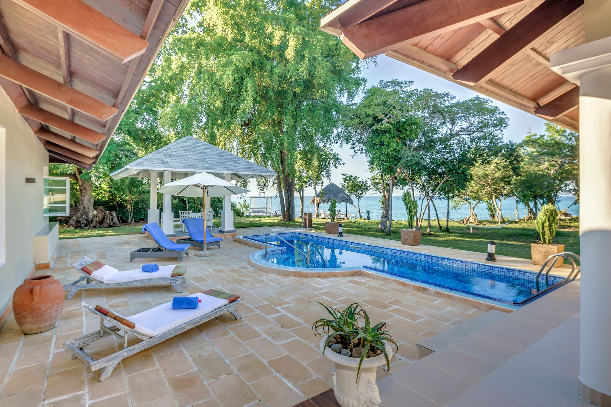 a pool with lounge chairs and a gazebo