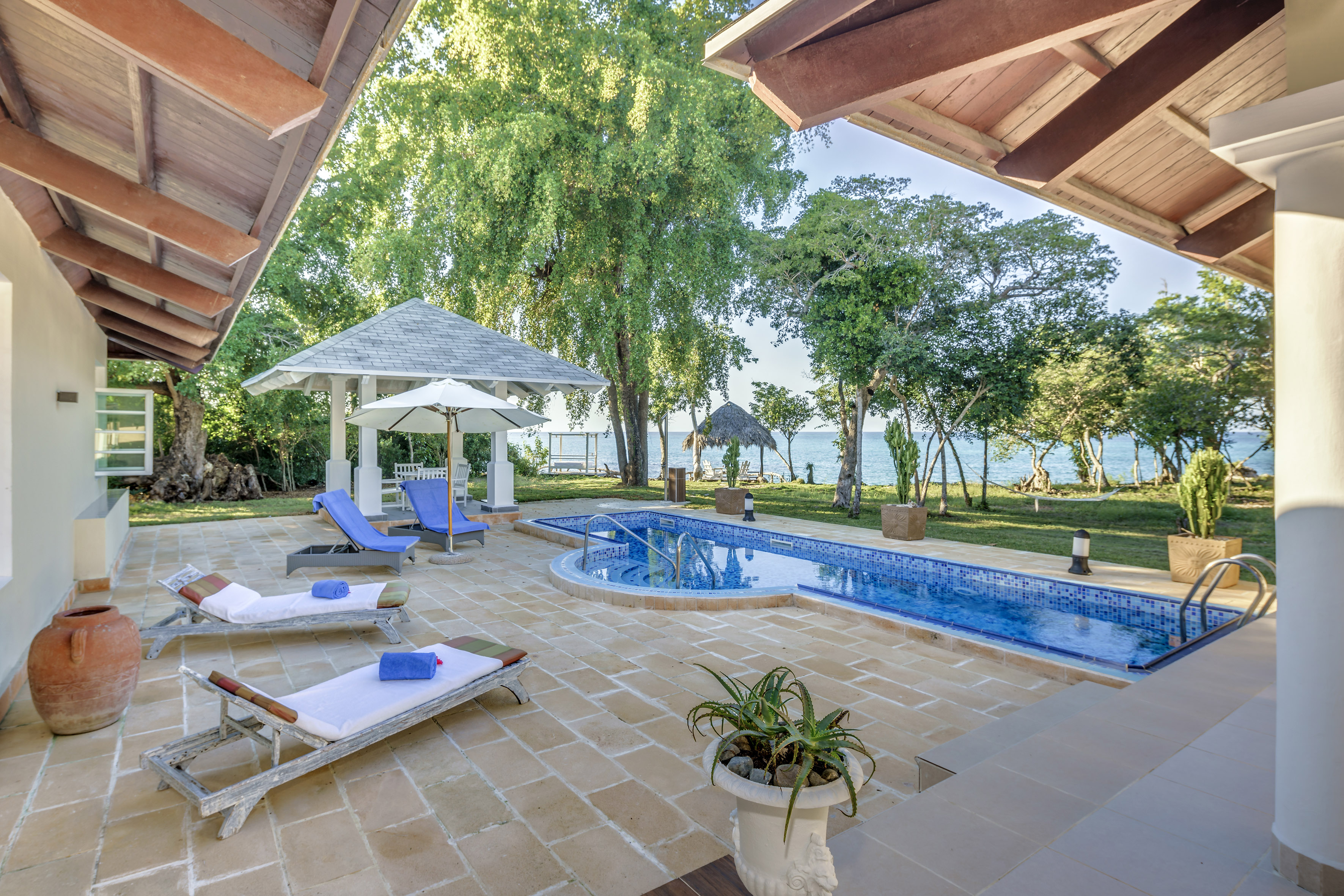 a pool with lounge chairs and a gazebo