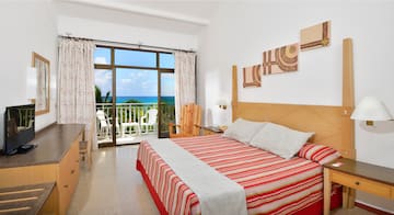 a bedroom with a large window overlooking the ocean