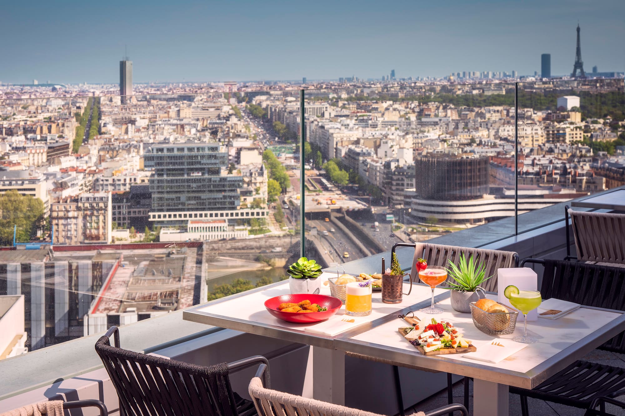 Terraza de azotea en París con comida, cócteles y vista a la Torre Eiffel.