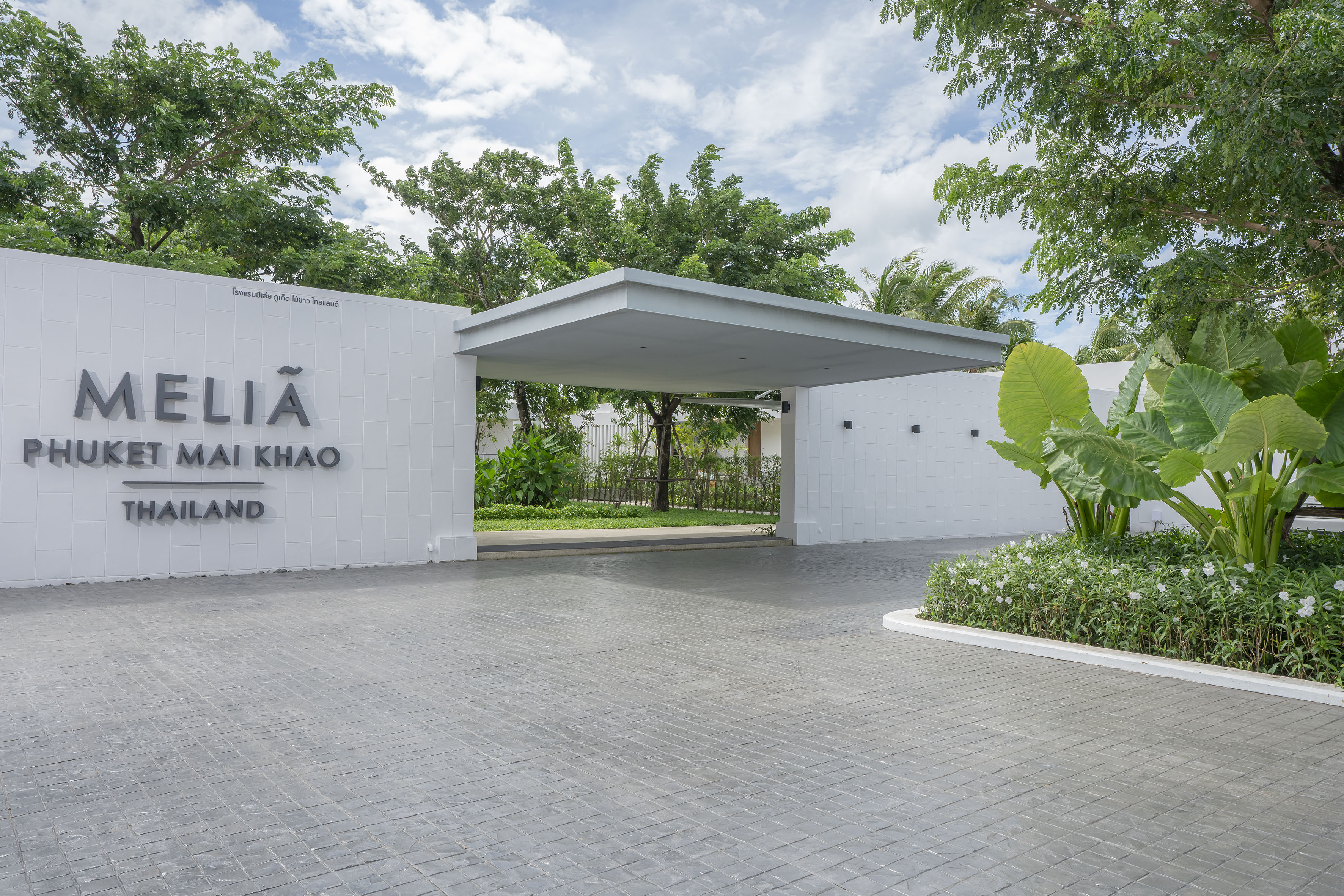 Meliá Phuket Mai Khao Thailand hotel entrance with modern architecture and lush greenery.