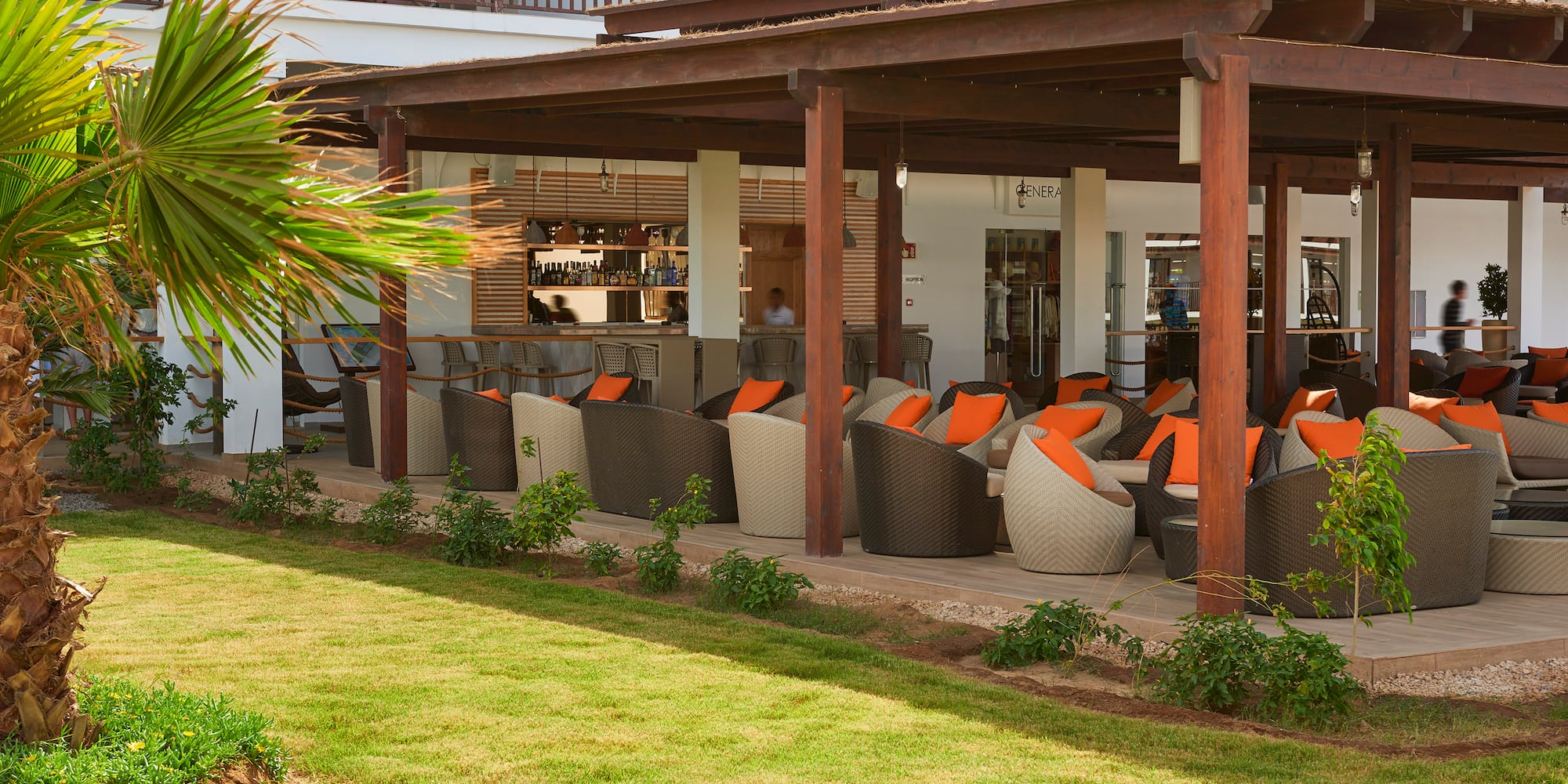 a patio area with chairs and a green lawn