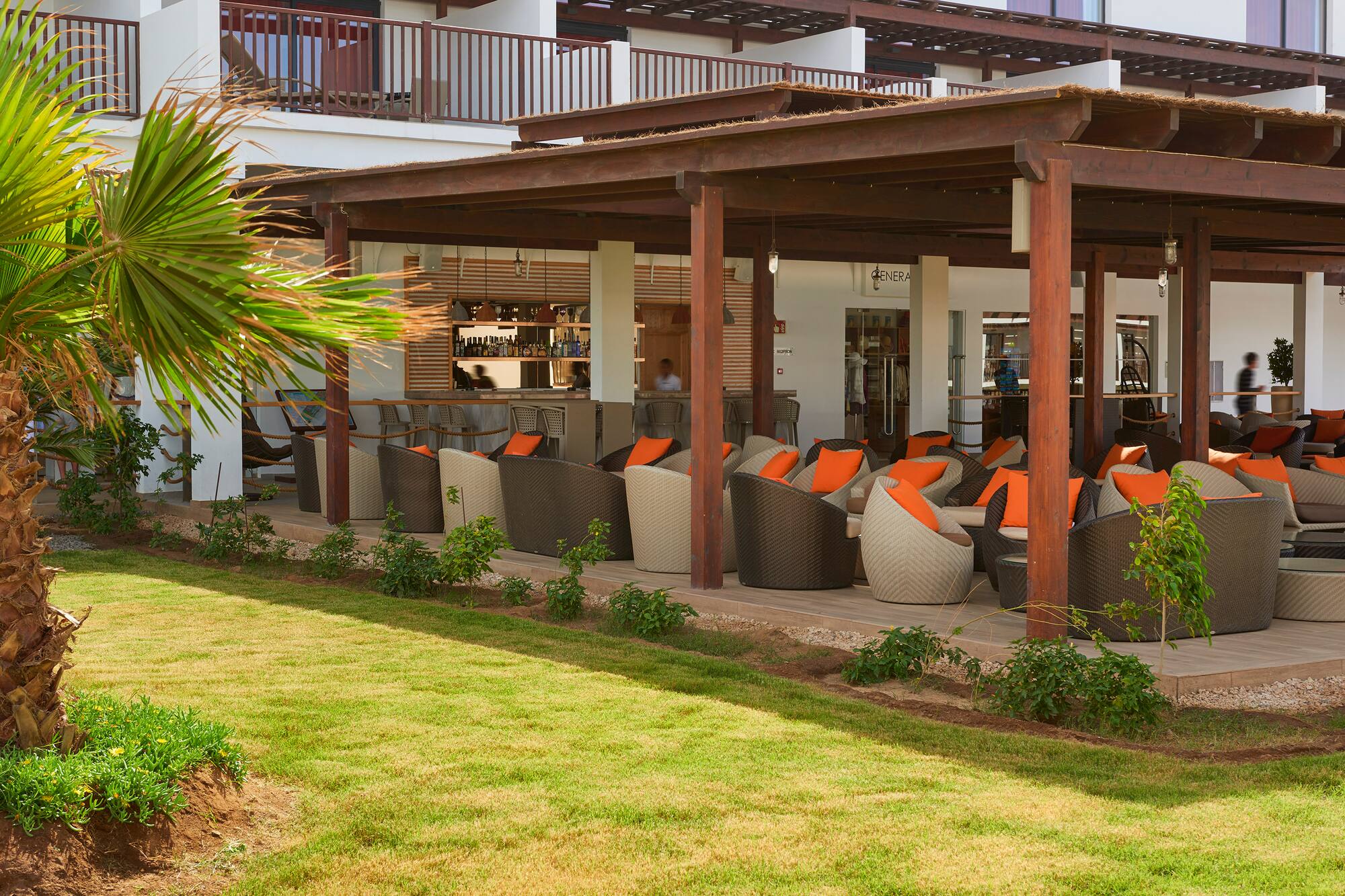 a patio area with chairs and a green lawn