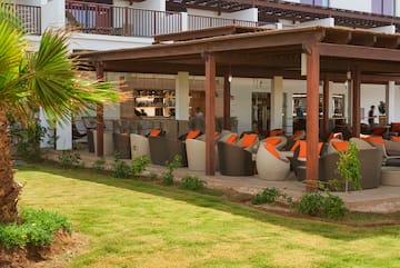 a patio area with chairs and a green lawn