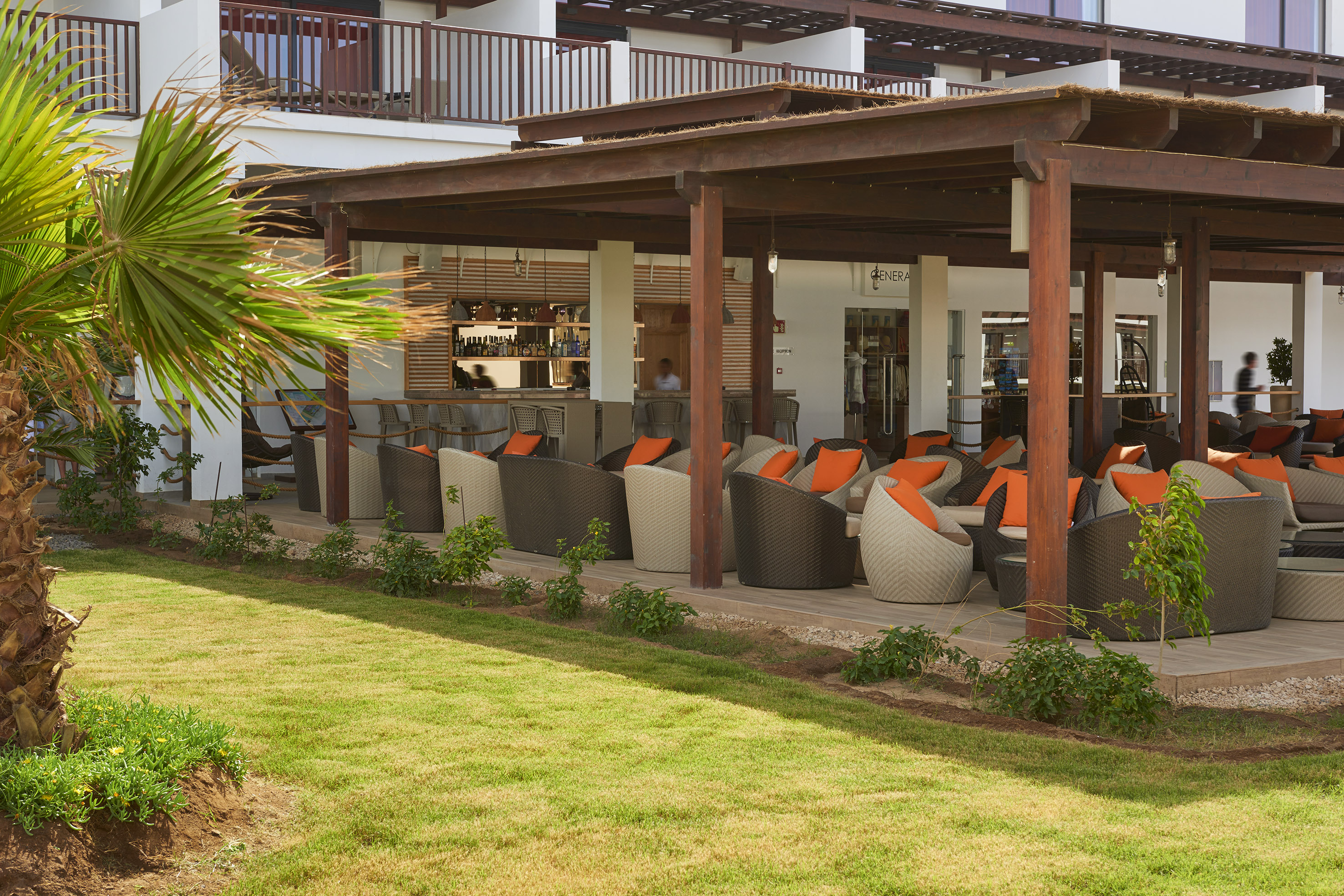 a patio area with chairs and a green lawn