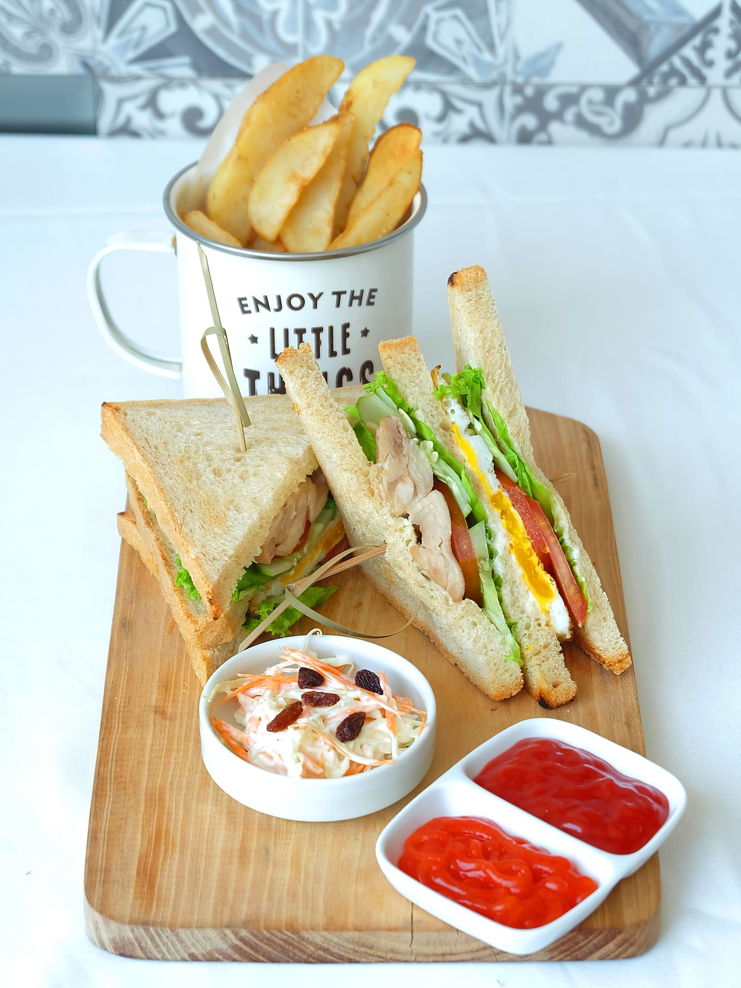 a sandwich and fries on a wooden board