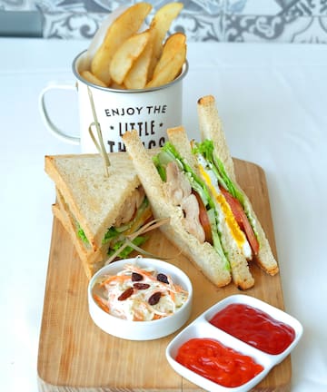 a sandwich and fries on a wooden board