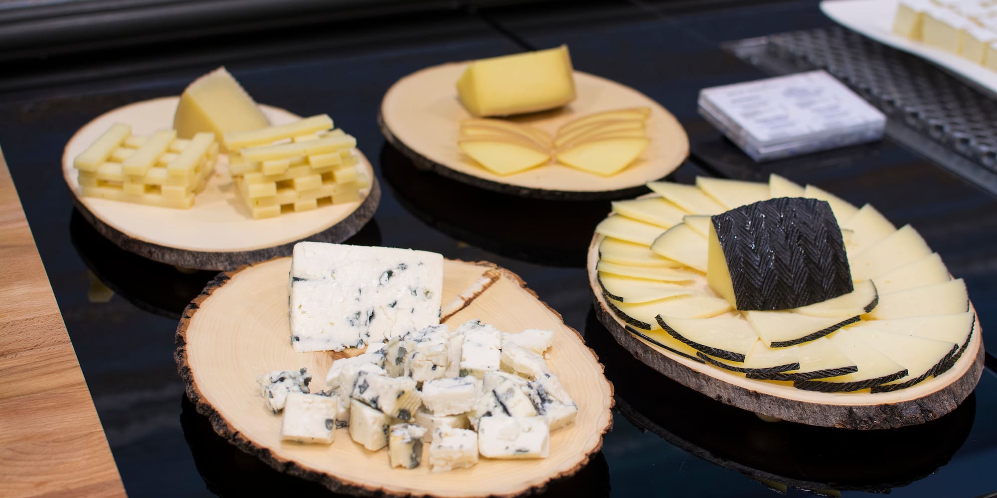 a group of wooden plates with different types of cheese