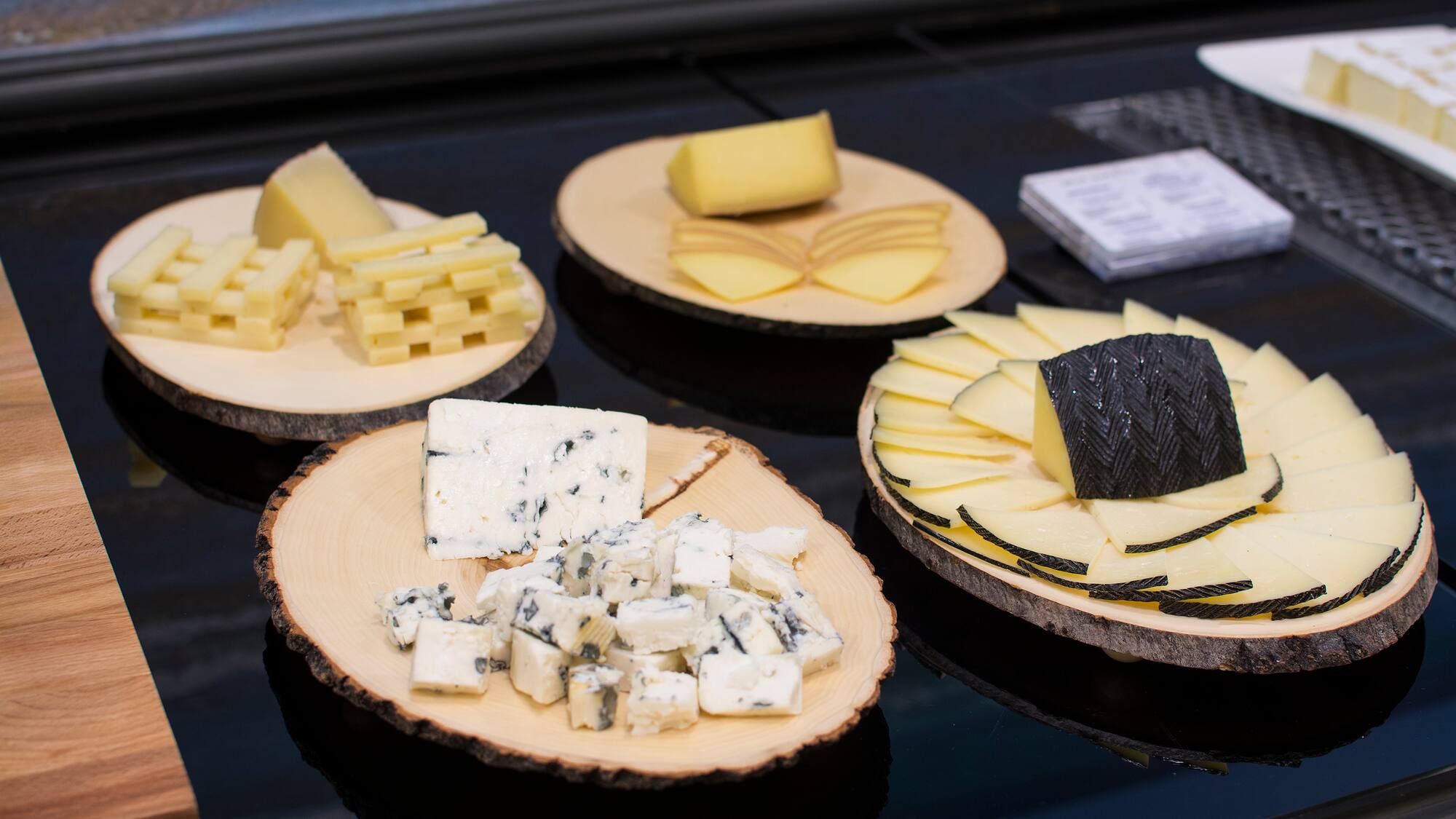 a group of wooden plates with different types of cheese