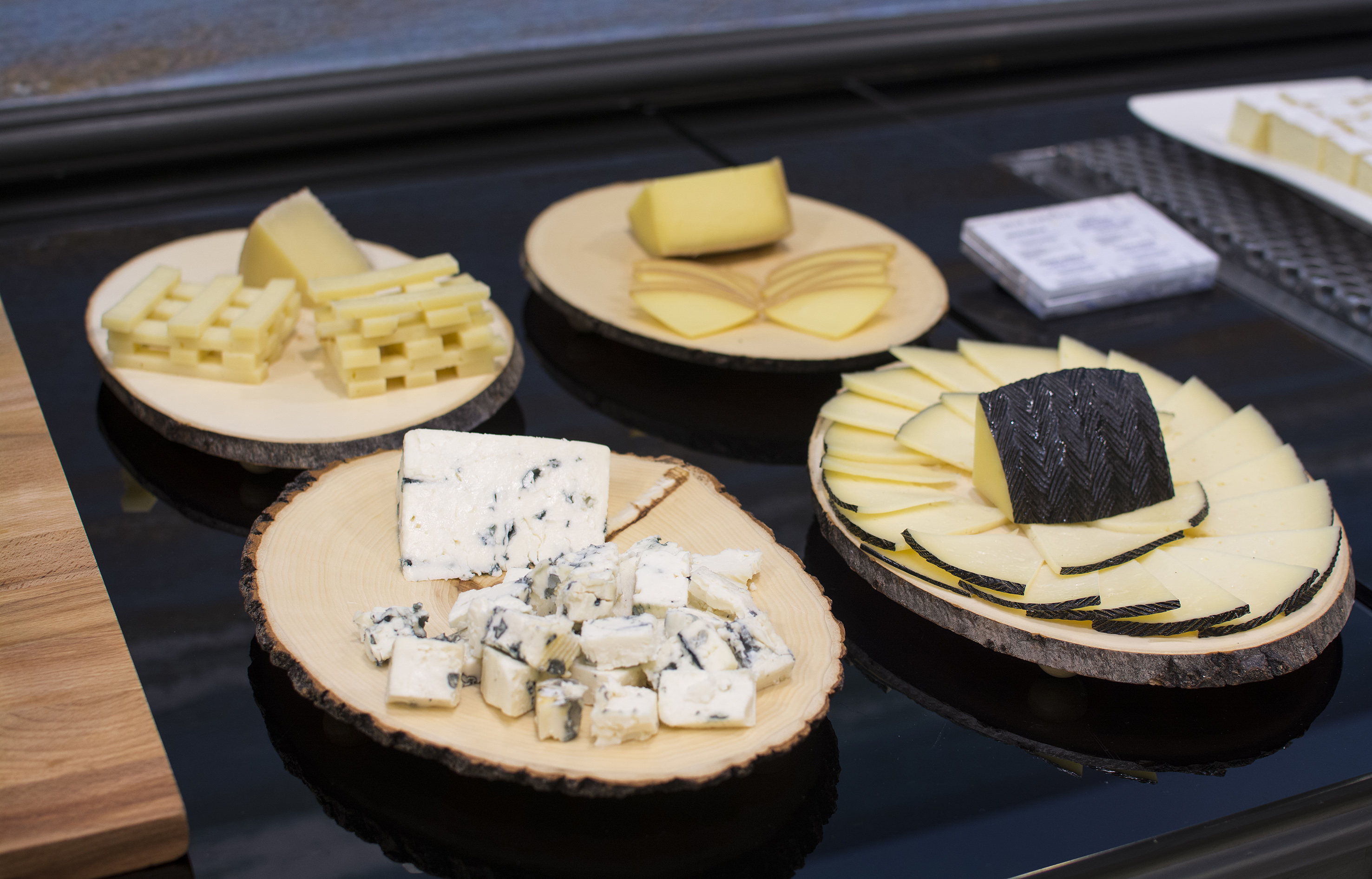 a group of wooden plates with different types of cheese