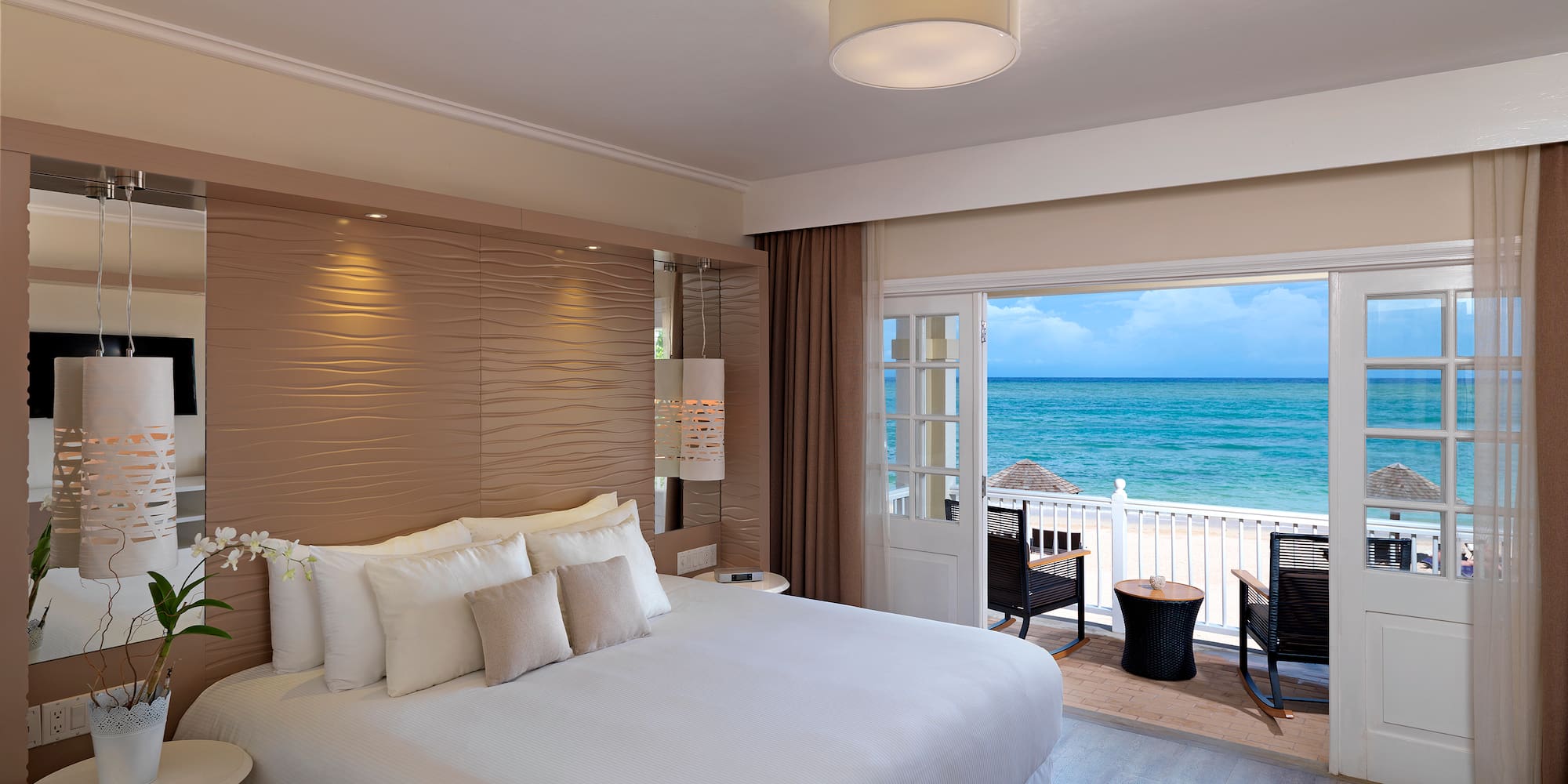 a room with a bed and a view of the ocean