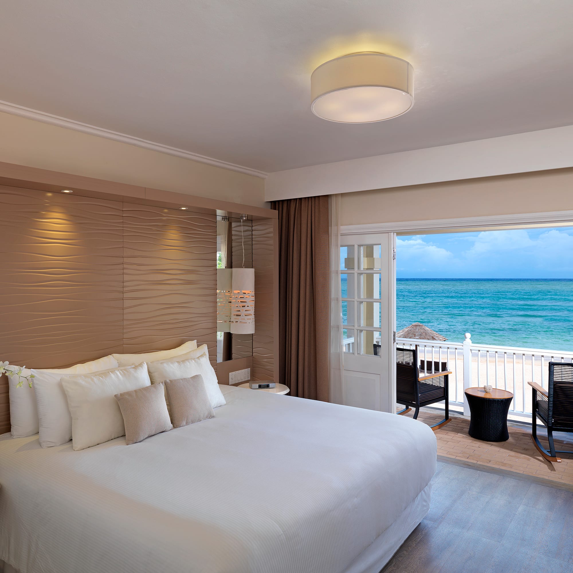 a room with a bed and a view of the ocean