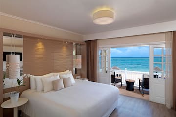 a room with a bed and a view of the ocean