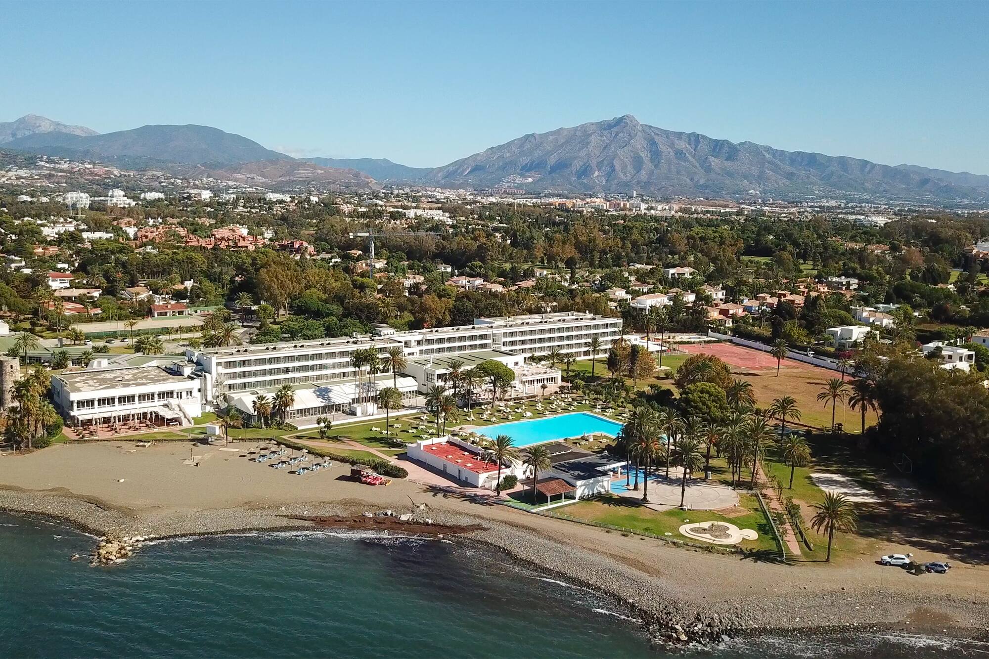 a beach with a swimming pool and a large building