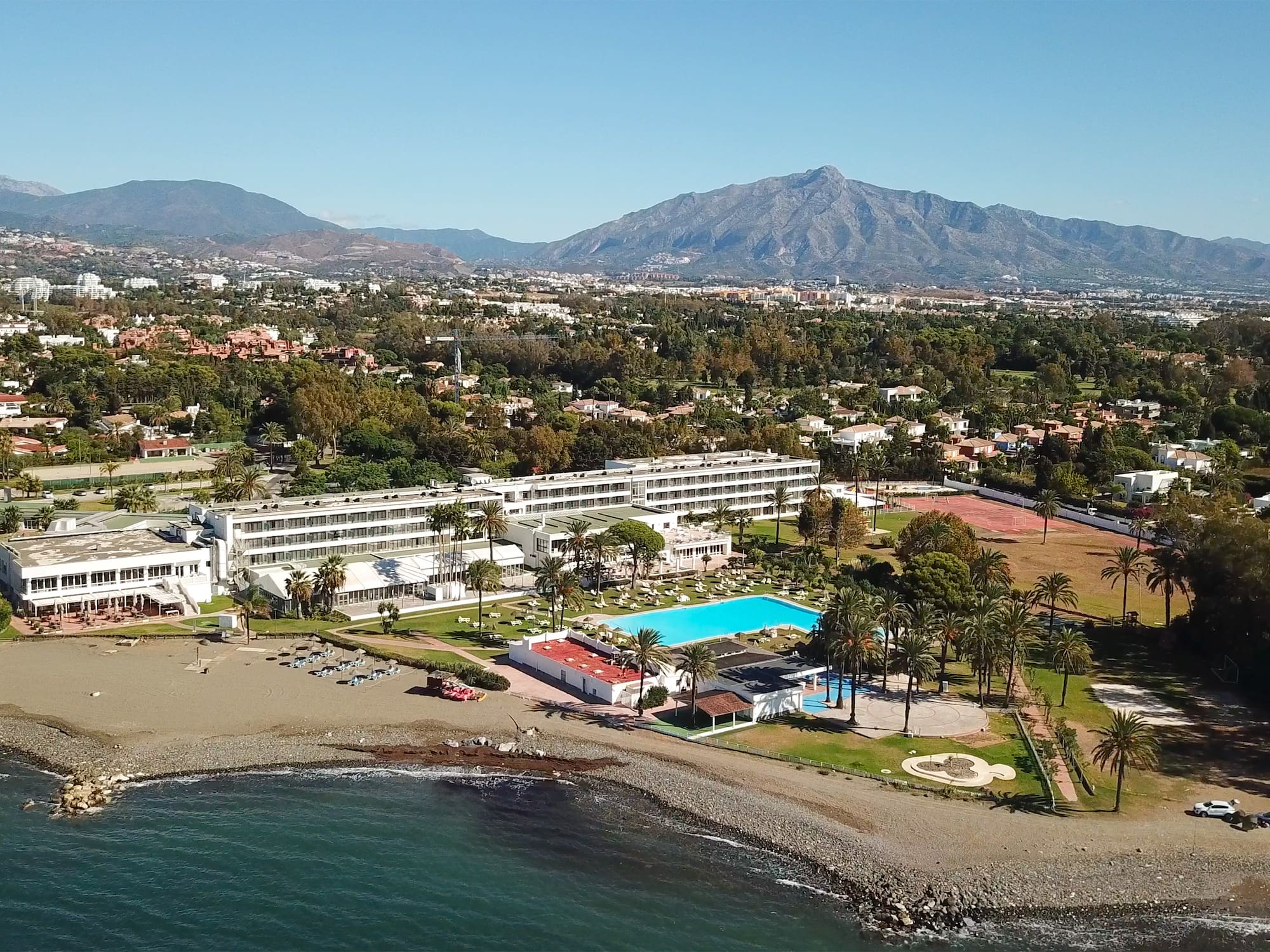 a beach with a swimming pool and a large building