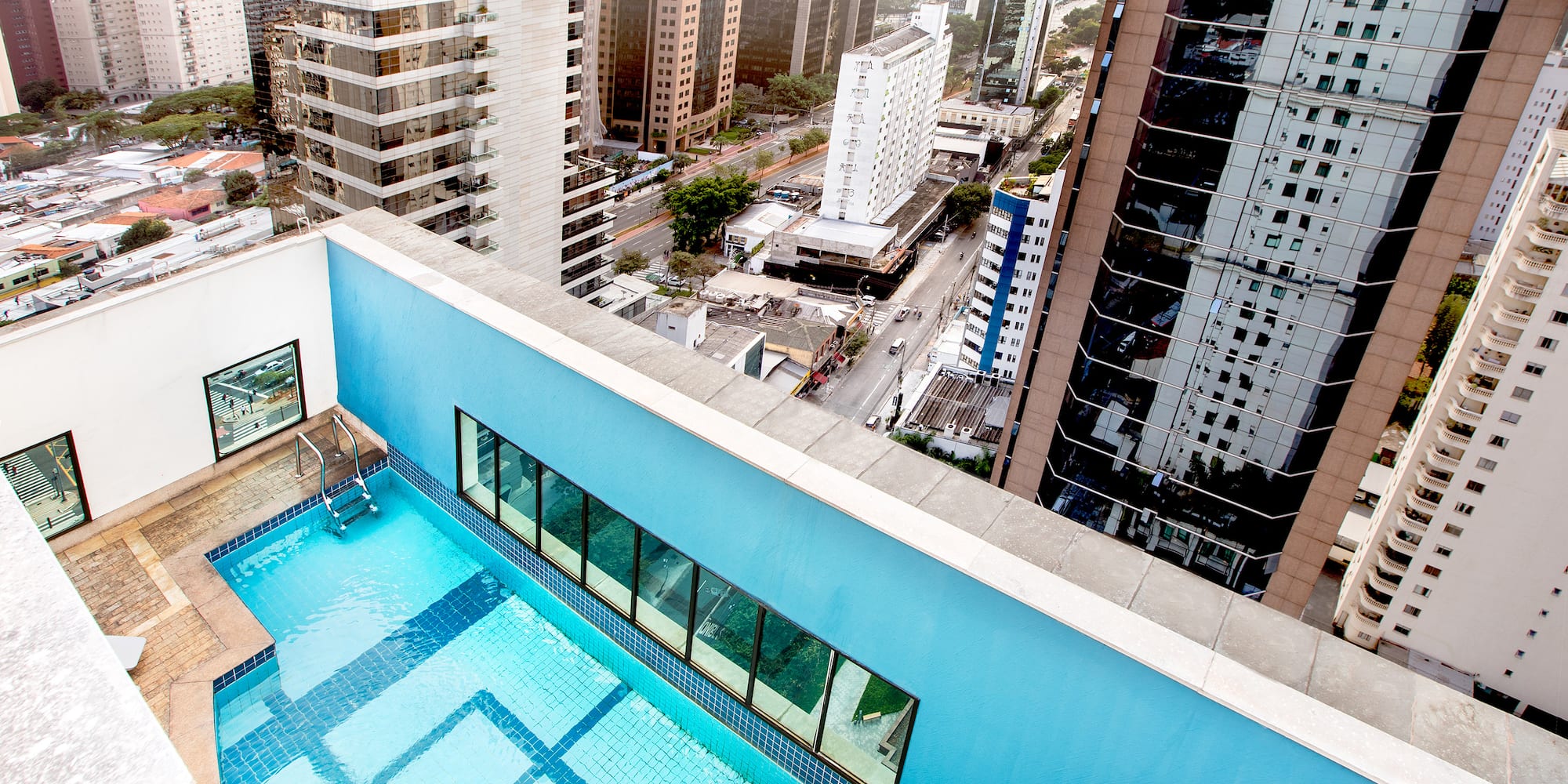 a rooftop pool with a city in the background