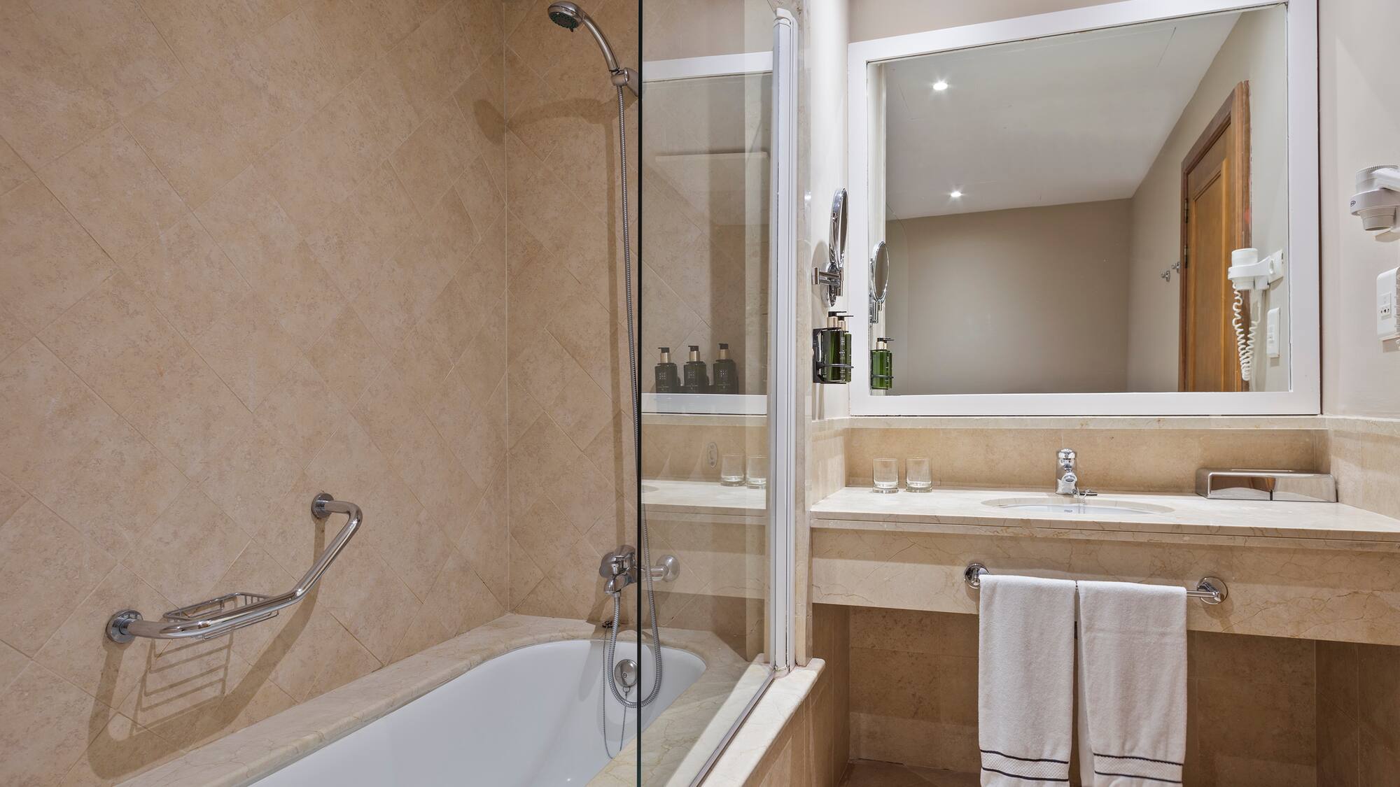 a bathroom with a glass shower and bathtub
