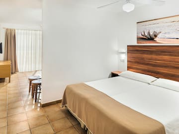 a bedroom with a bed and a picture on the wall