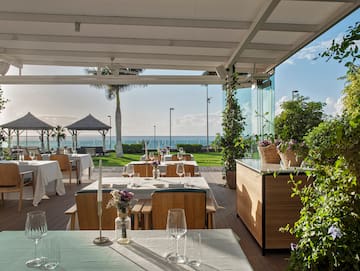 a restaurant with tables and chairs and plants