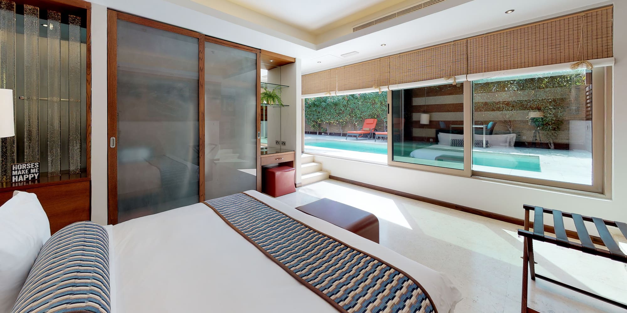 a bedroom with a bed and a pool in the background