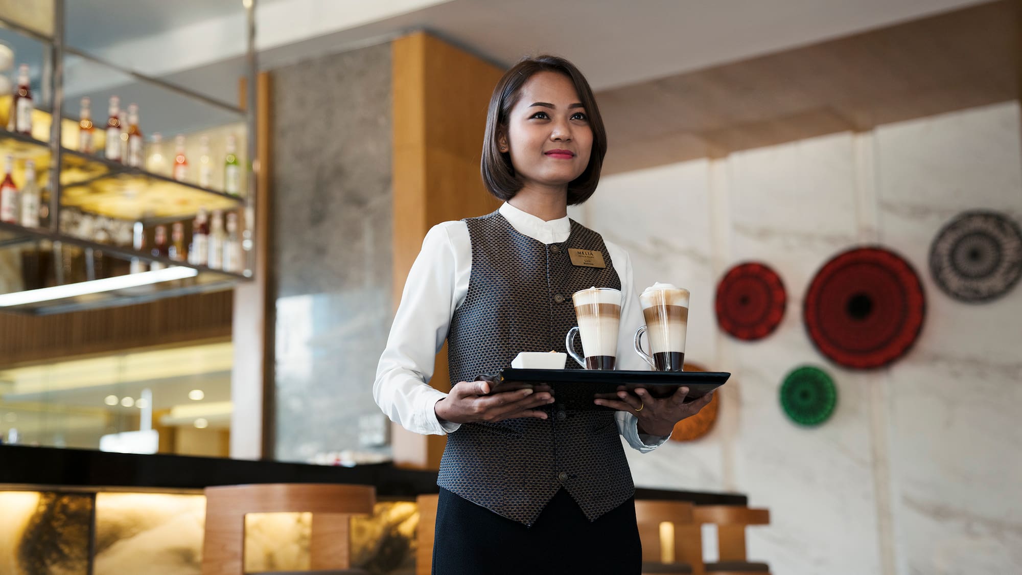 a woman holding a tray of coffee