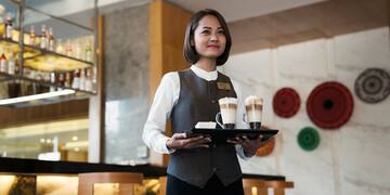 a woman holding a tray of coffee