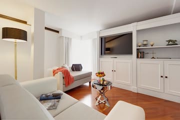 a living room with white furniture and a tv