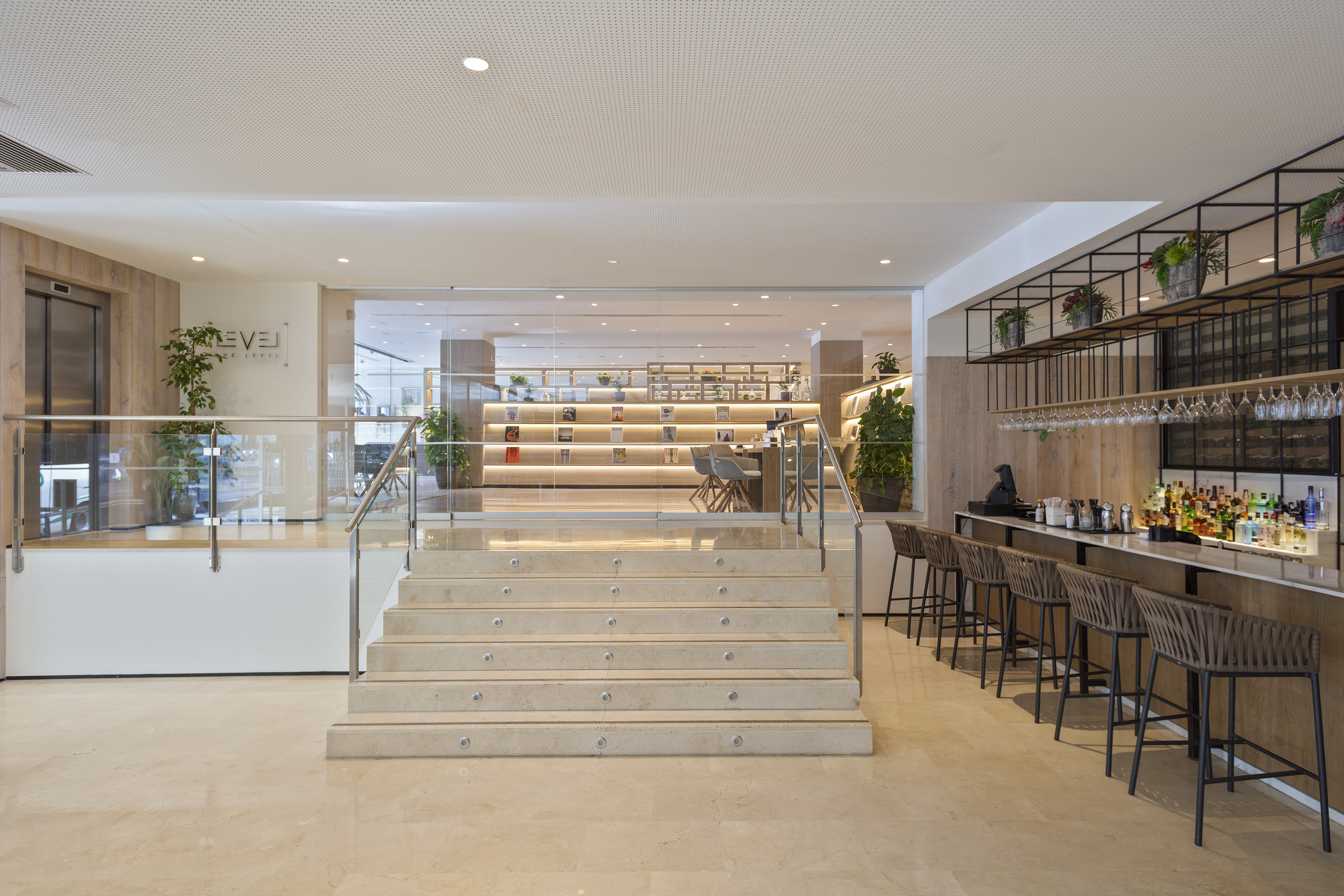 Hotel reception area with stairs, bar, and illuminated library lounge.