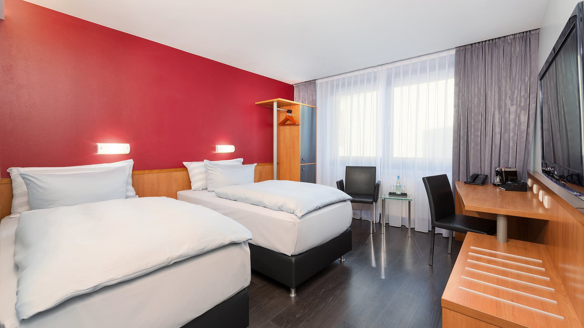 a room with two beds and a desk