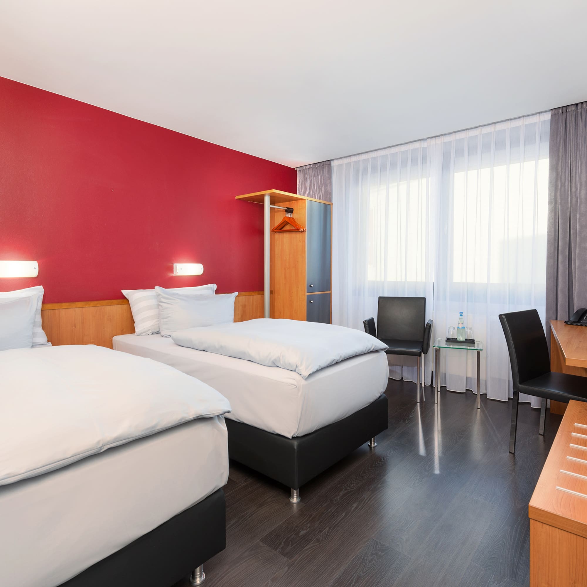 a room with two beds and a desk