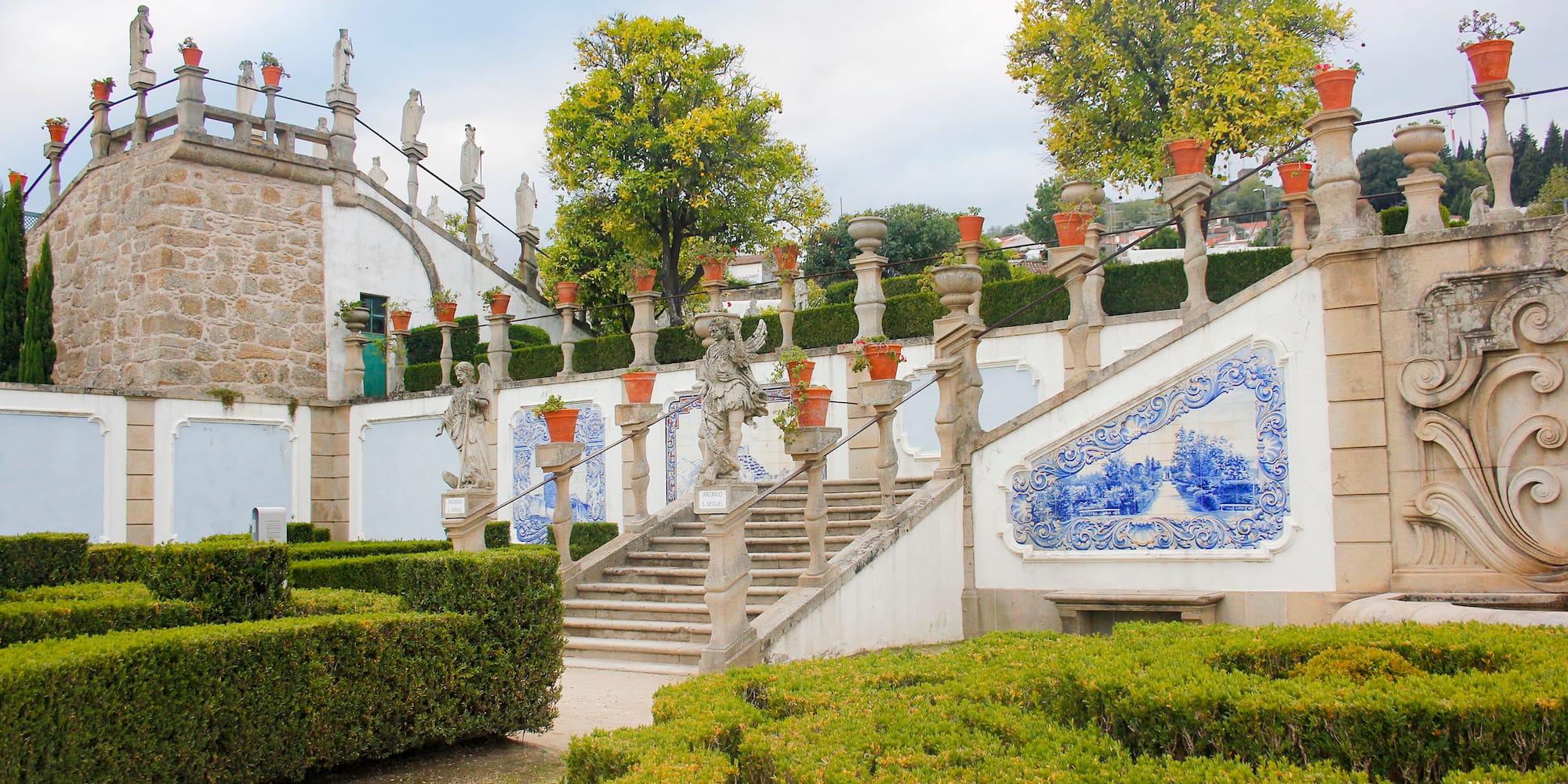 a stone staircase with a garden and bushes