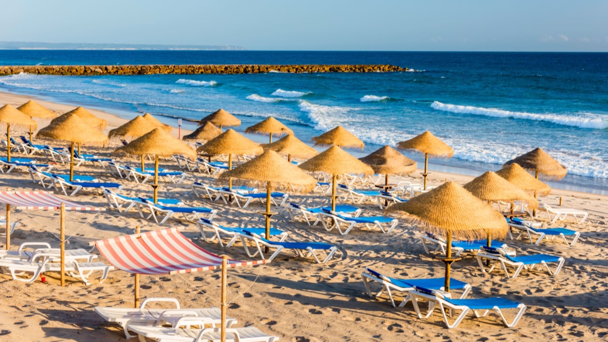 a beach with umbrellas and chairs