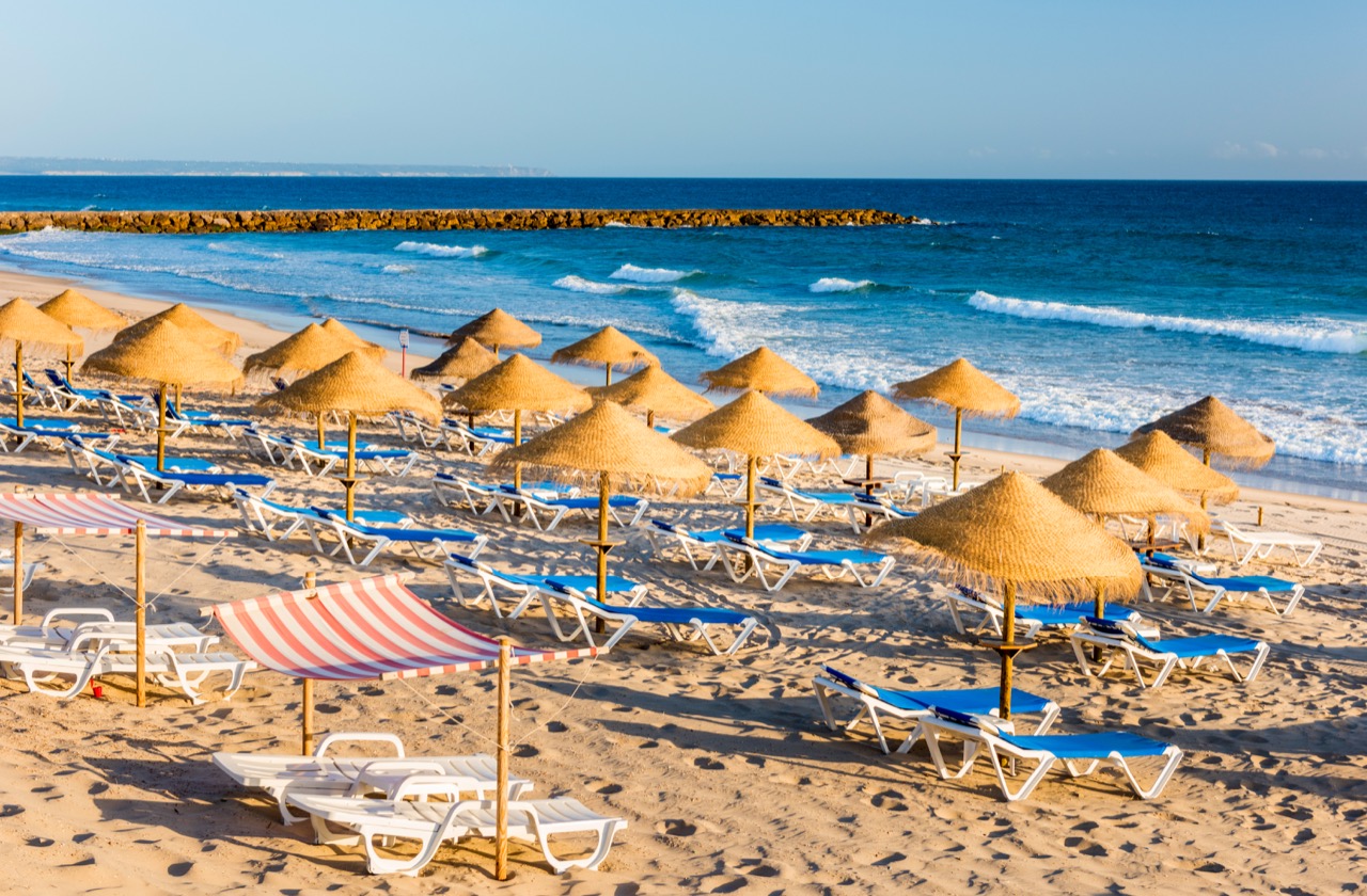 a beach with umbrellas and chairs