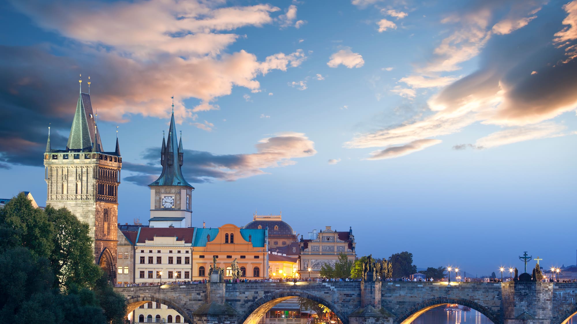a bridge over water with buildings and trees
