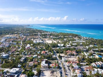 a city with many houses and trees next to the ocean