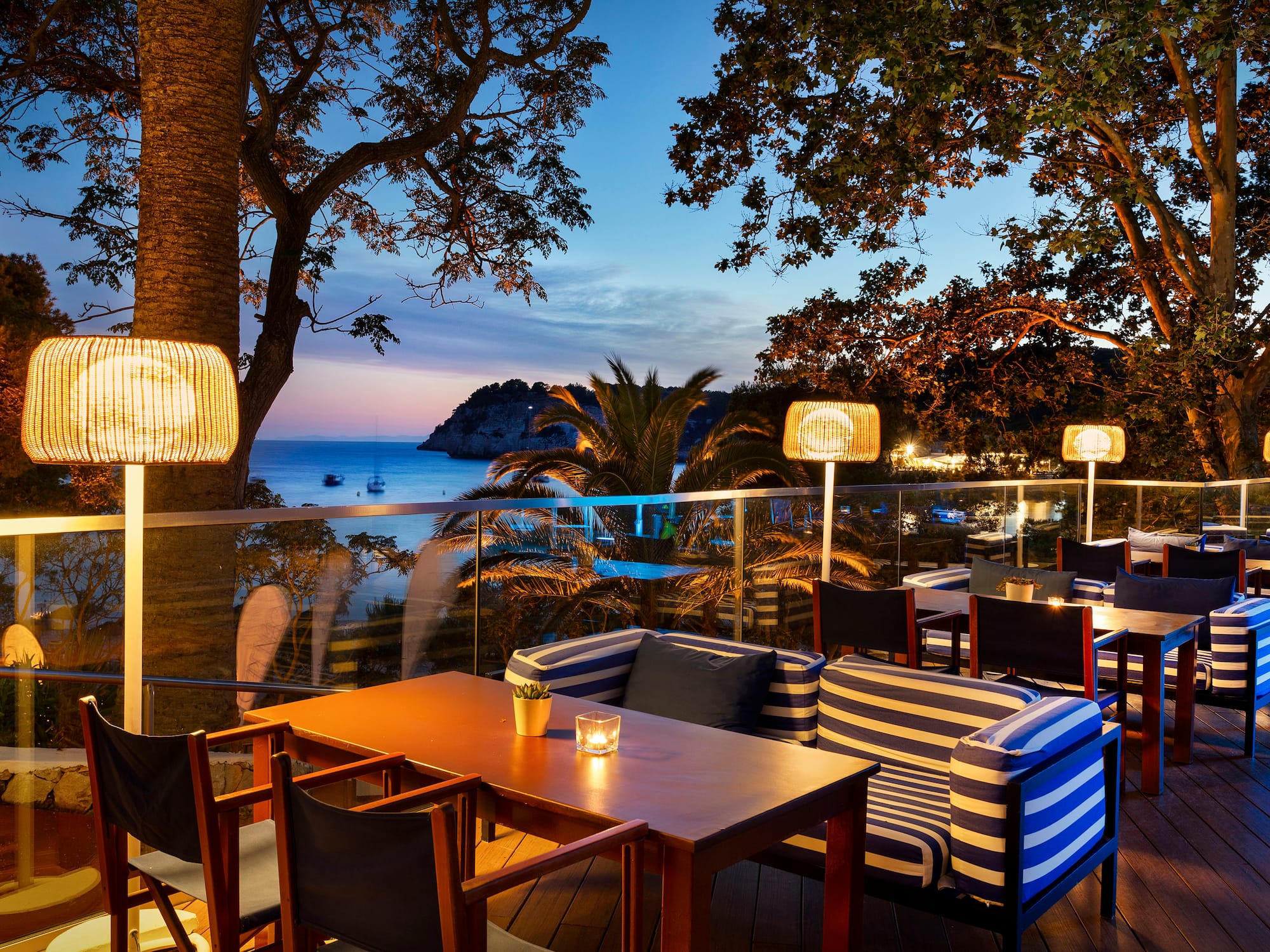 a table and chairs on a deck with a view of the ocean