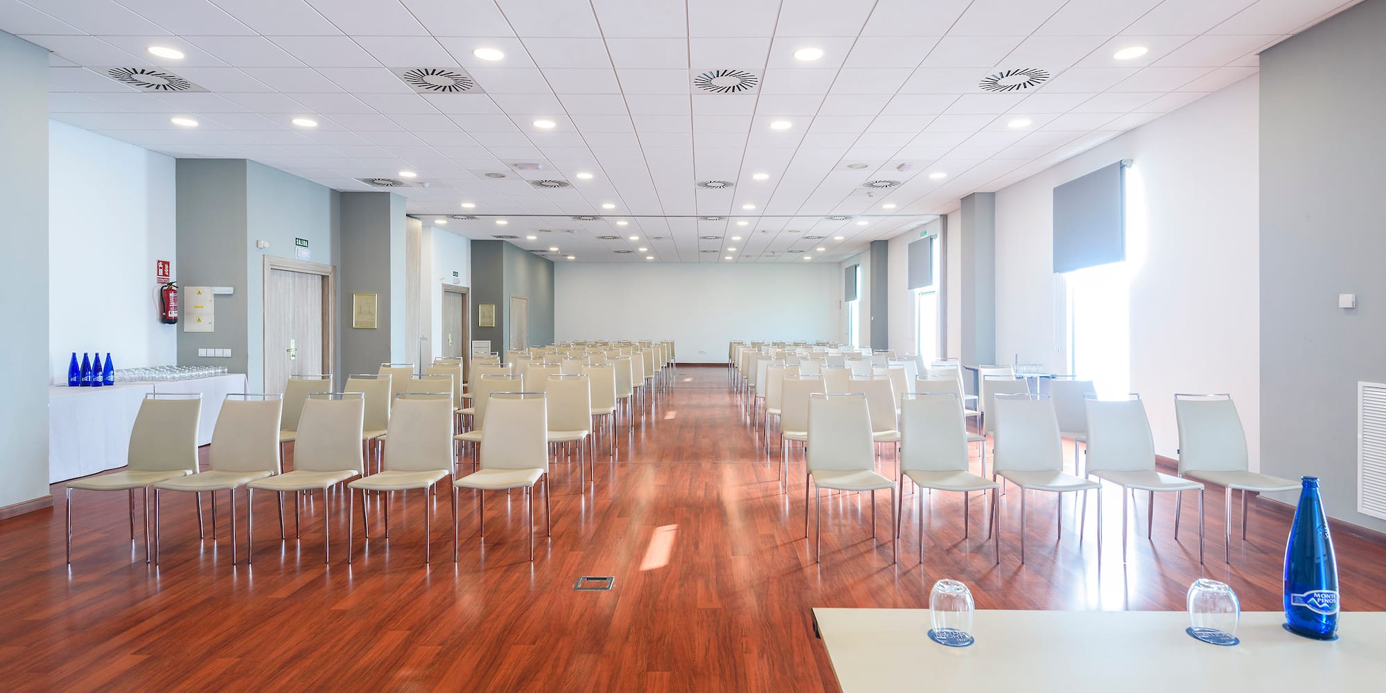 a room with white chairs and tables