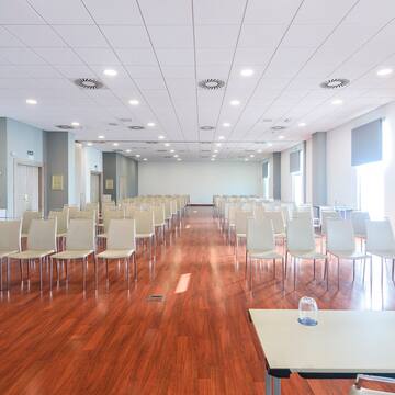 a room with white chairs and tables
