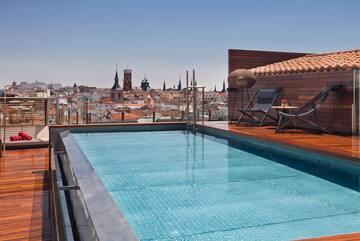 a pool on a roof with a city in the background