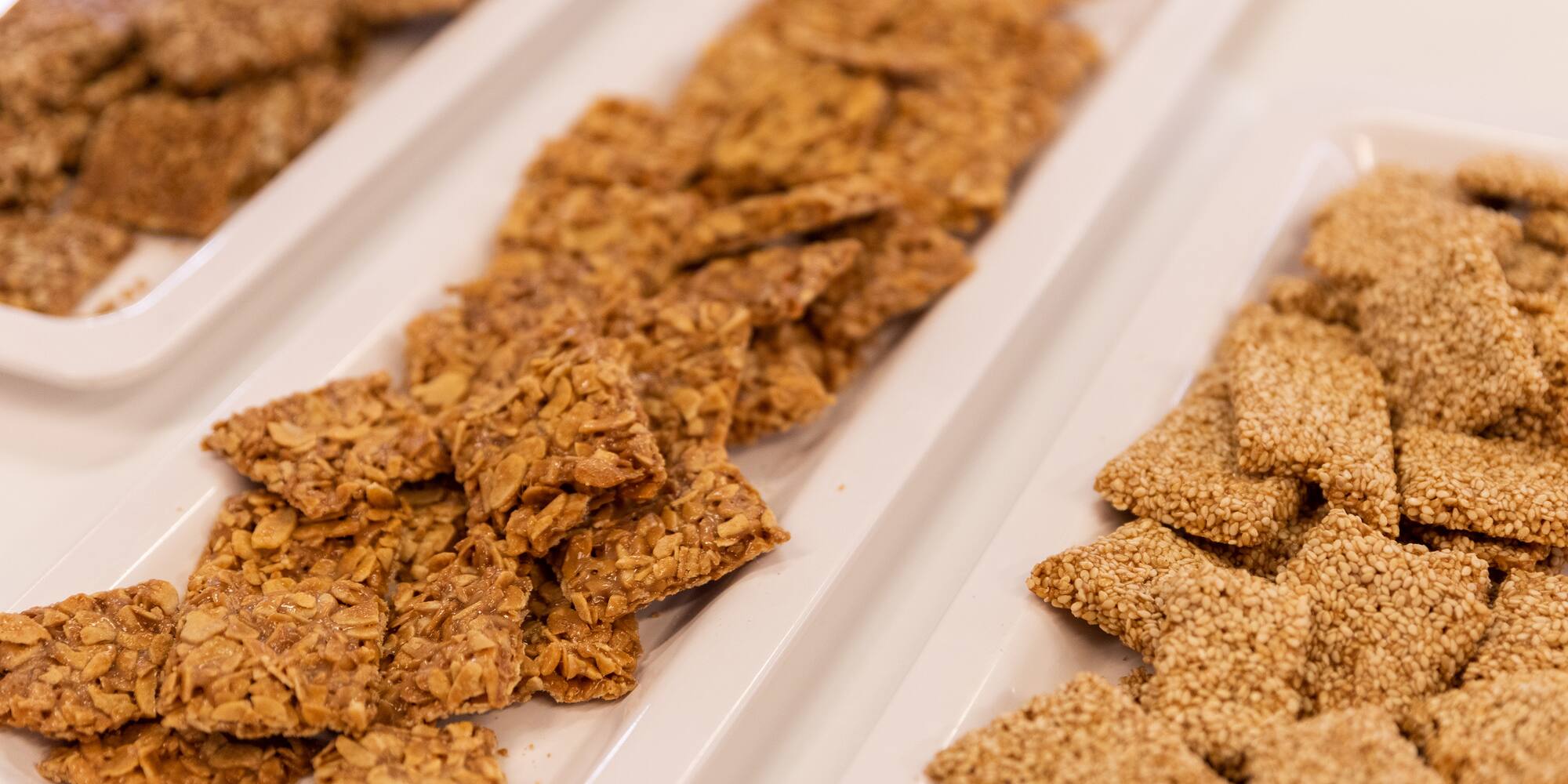 a group of rectangular white plates with food on them