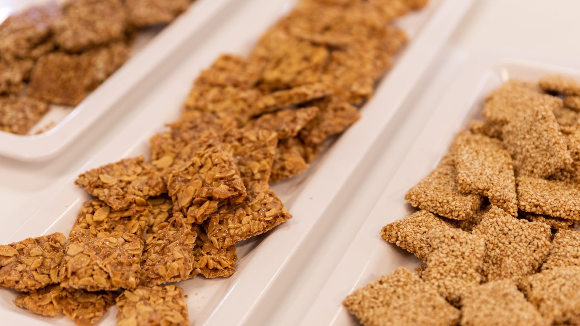 a group of rectangular white plates with food on them