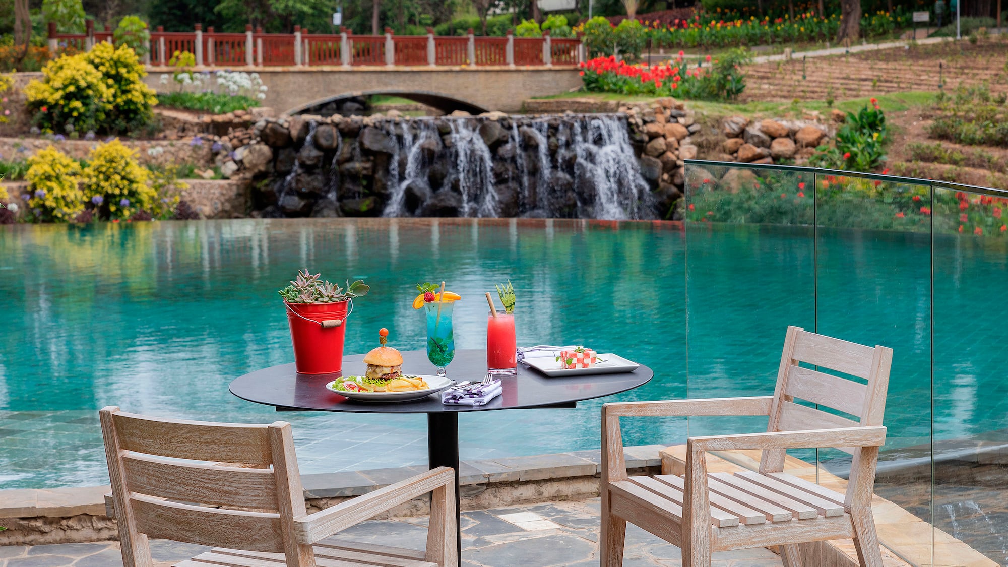 a table with food and drinks on it by a pool