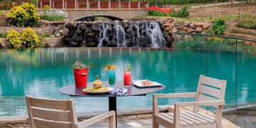 a table with food and drinks on it by a pool