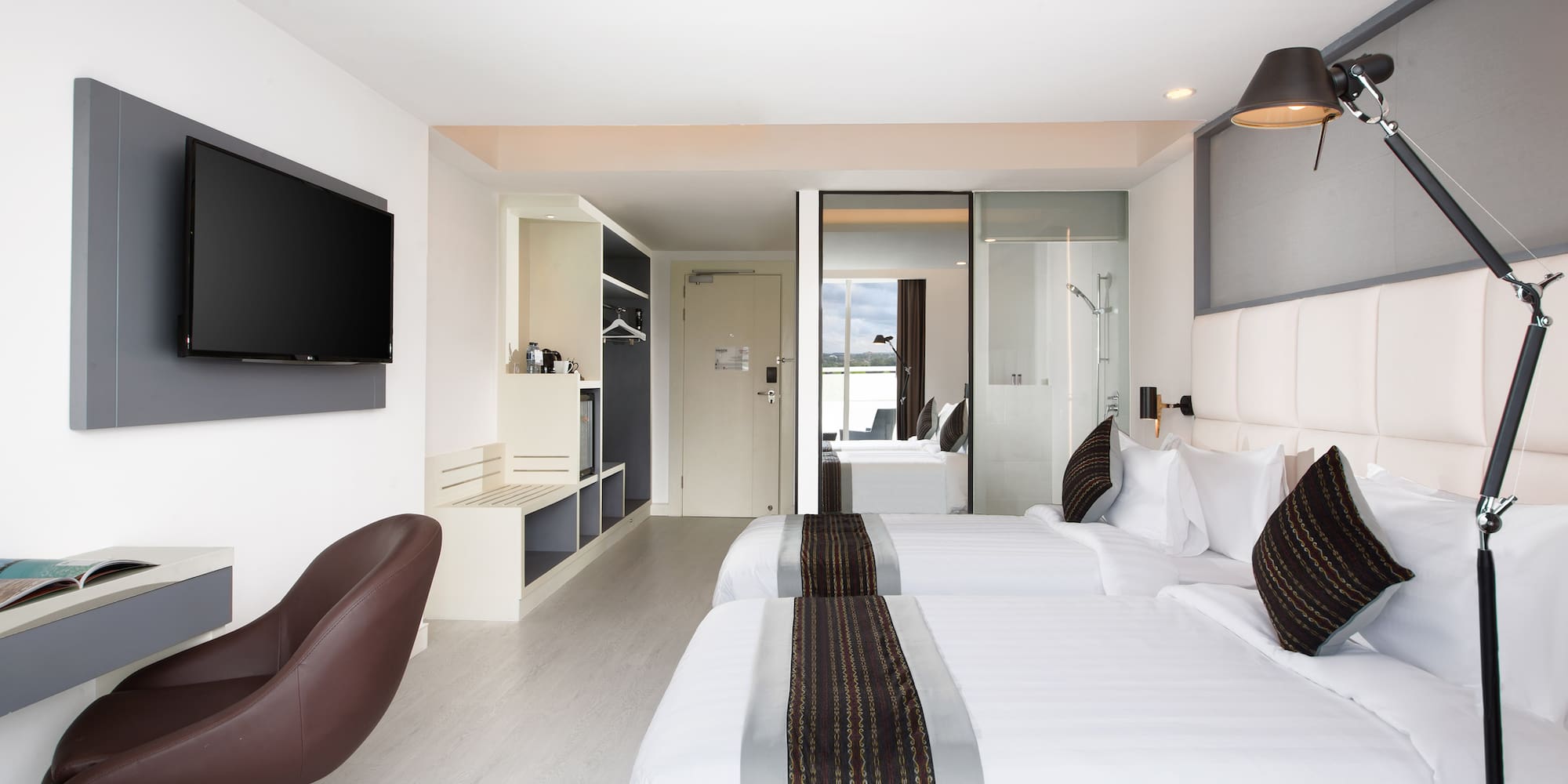 a room with white beds and a brown chair