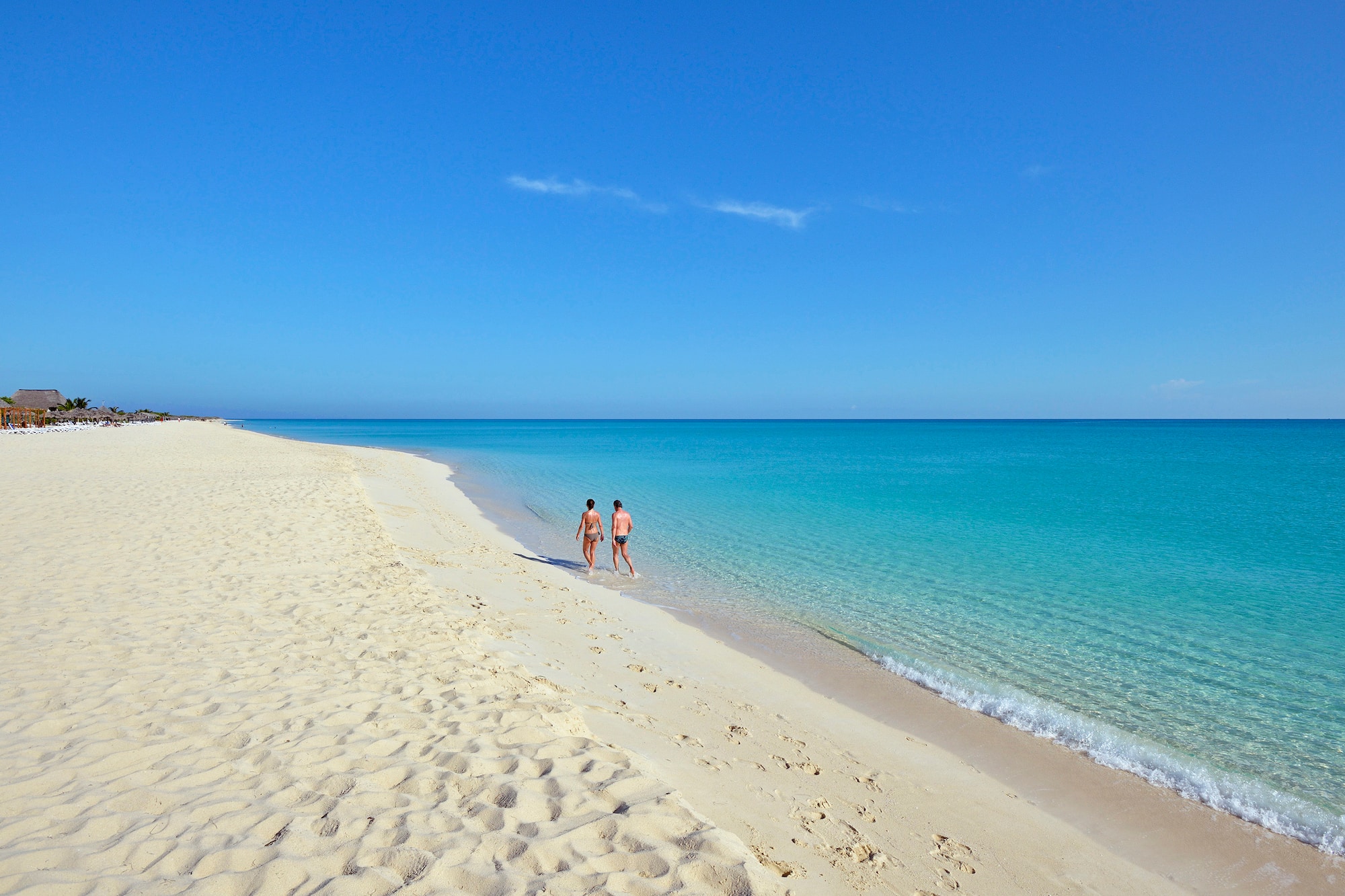 two people walking on a beach