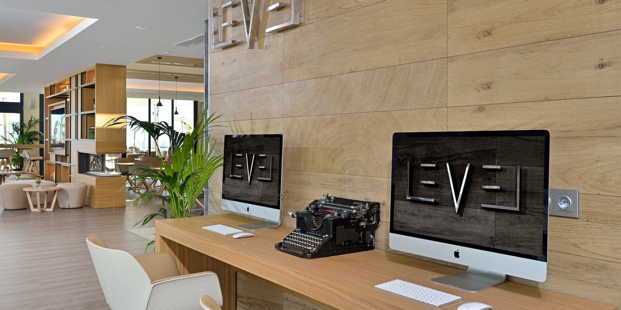 a desk with computers and a typewriter