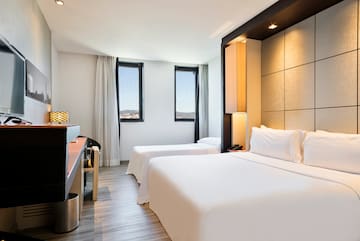 a room with two beds and a piano